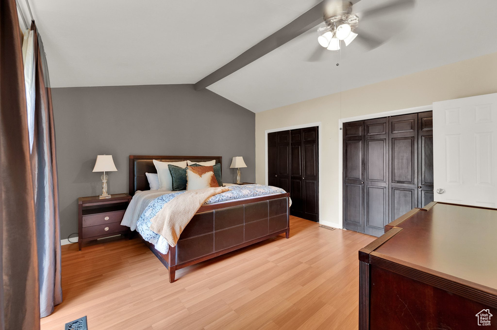 Bedroom featuring light wood-style floors, multiple closets, and a ceiling fan