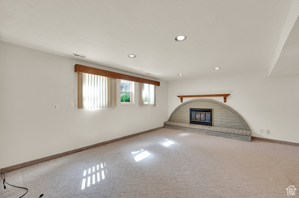Unfurnished living room with carpet, a fireplace, and recessed lighting