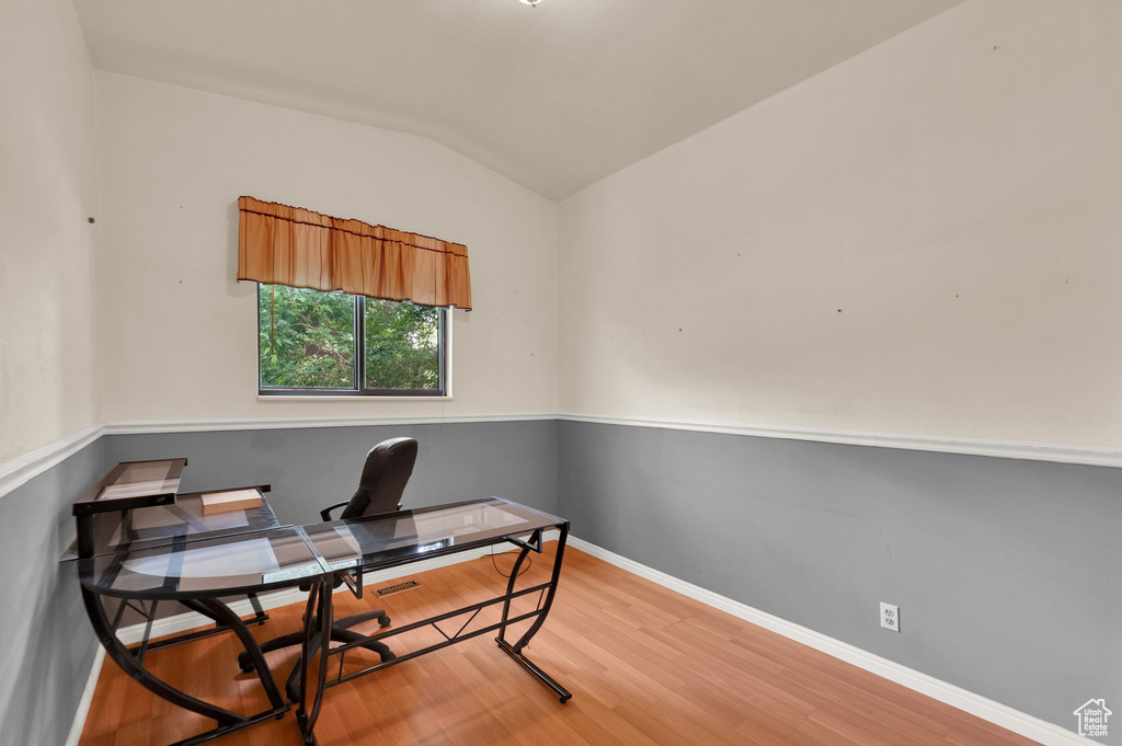 Office area with lofted ceiling and wood finished floors