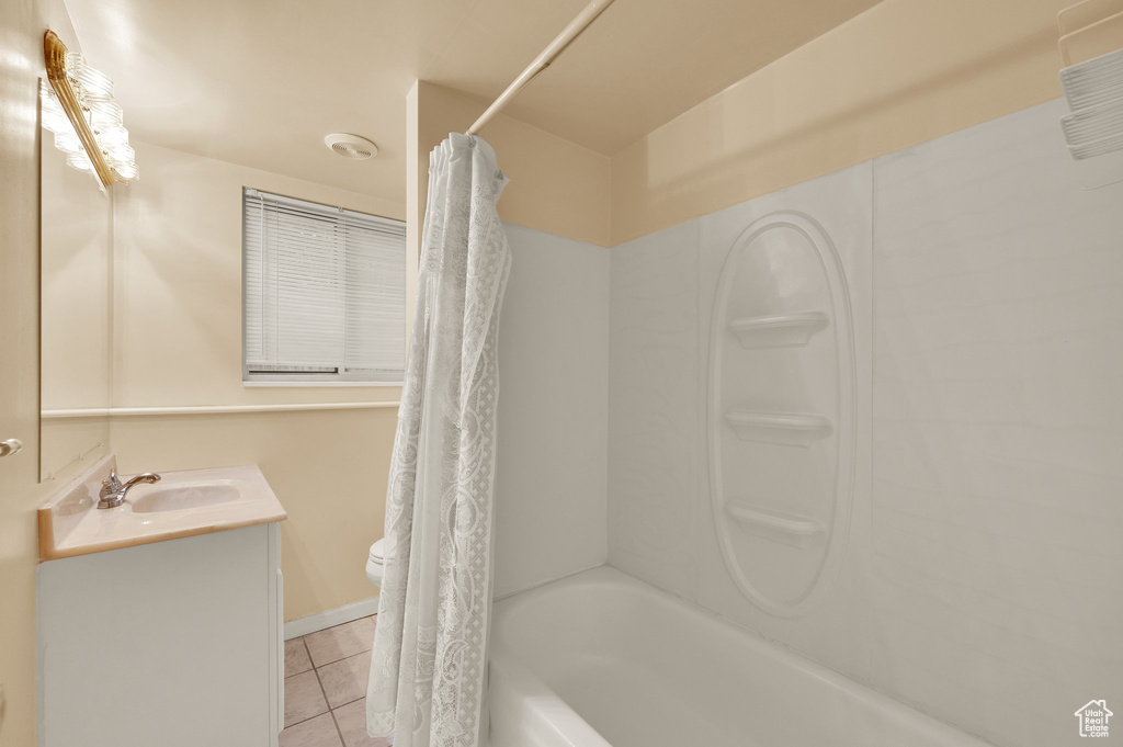 Bathroom featuring tile patterned flooring, shower / tub combo, and vanity