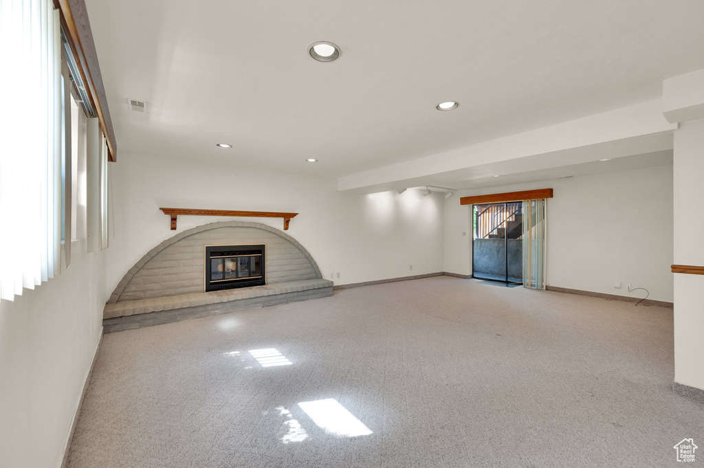 Unfurnished living room with a fireplace, recessed lighting, and carpet flooring