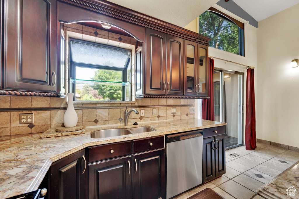 Kitchen with dishwasher, decorative backsplash, glass insert cabinets, and dark brown cabinets