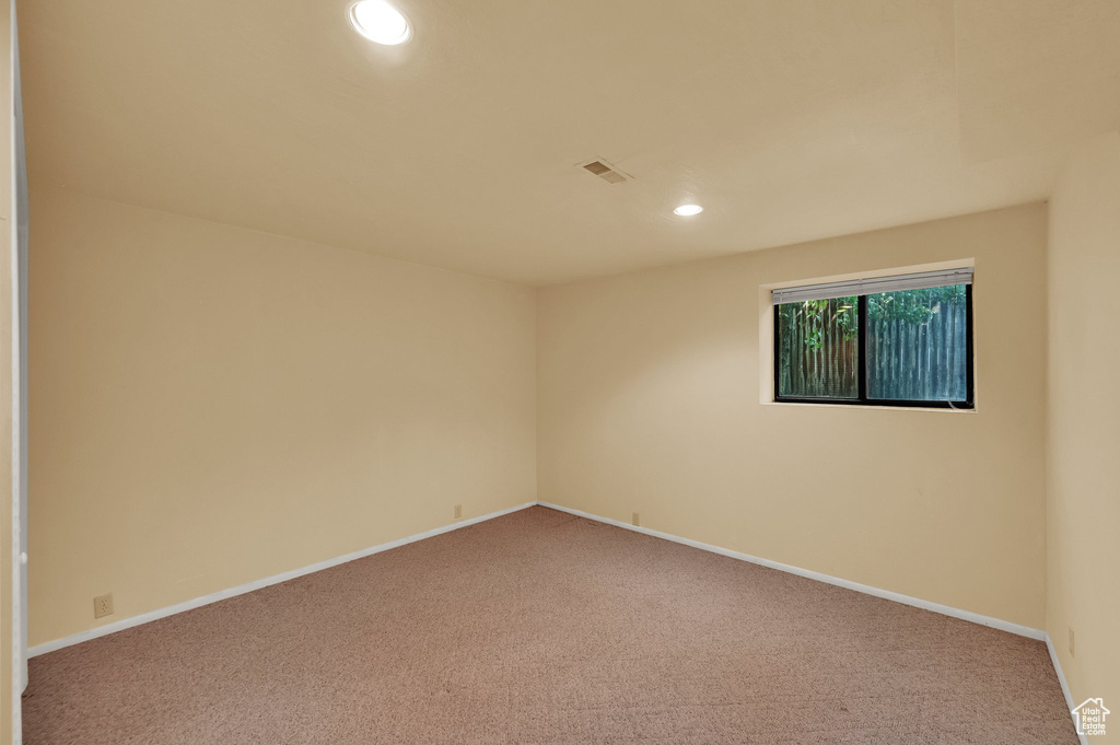 Carpeted empty room featuring recessed lighting and baseboards
