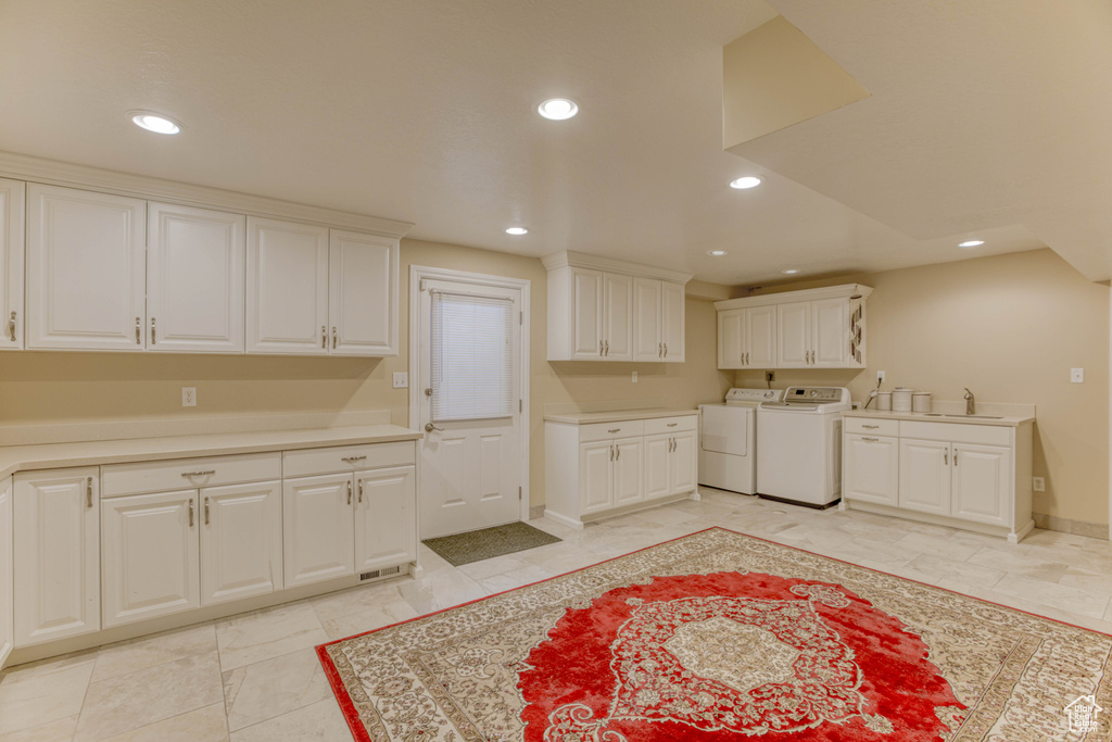 Washroom featuring separate washer and dryer, cabinet space, and recessed lighting