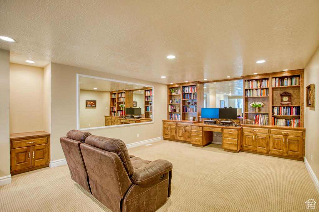 Office area featuring light carpet, built in desk, recessed lighting, and a textured ceiling