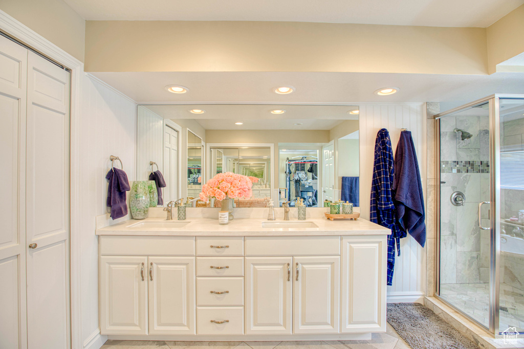 Full bathroom featuring a closet, double vanity, a shower stall, recessed lighting, and tile patterned flooring