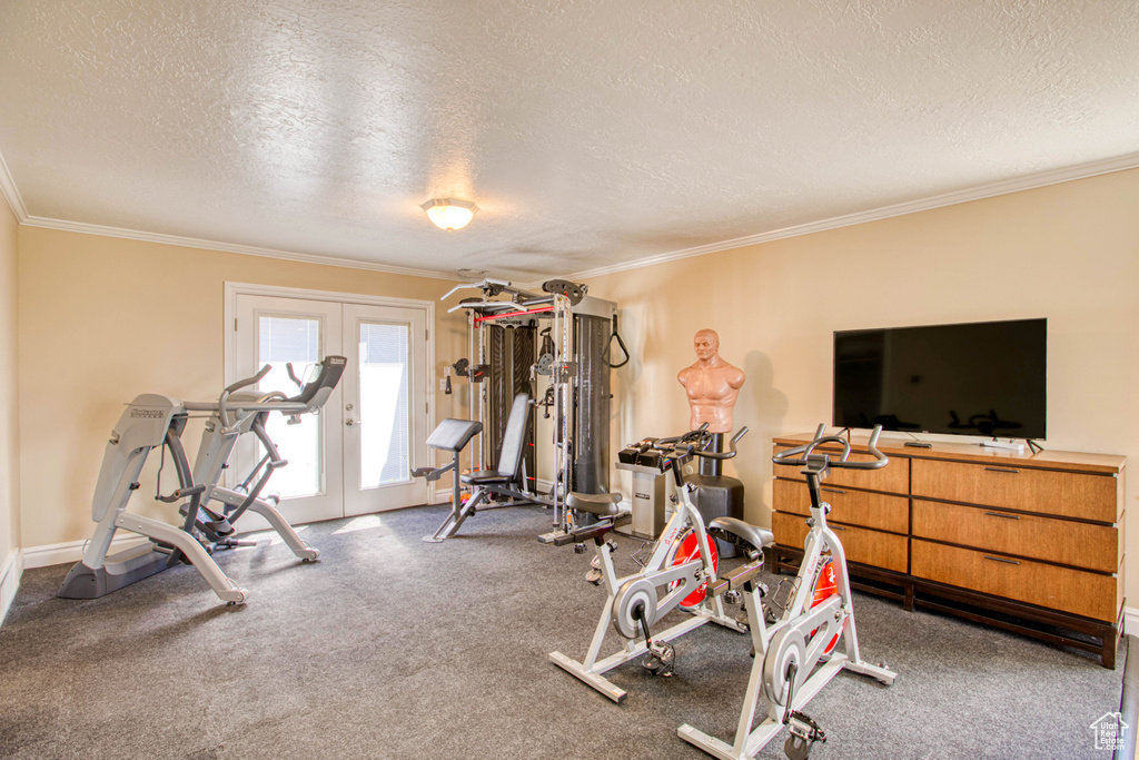 Workout room with a textured ceiling, ornamental molding, and french doors