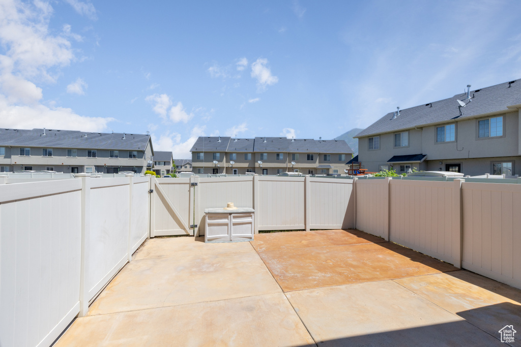 Fenced backyard with a gate, a residential view, and a patio