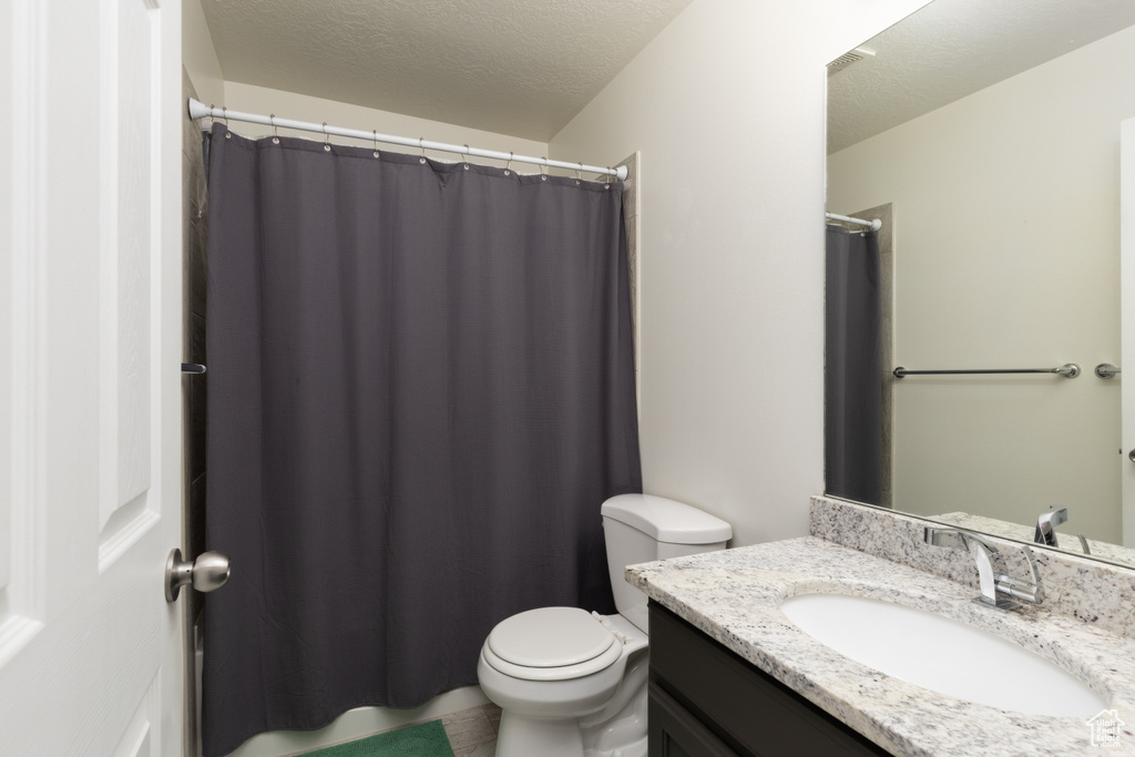 Full bathroom with vanity, a textured ceiling, and a shower with shower curtain