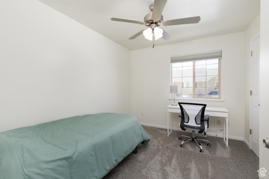 Carpeted bedroom featuring baseboards and a ceiling fan