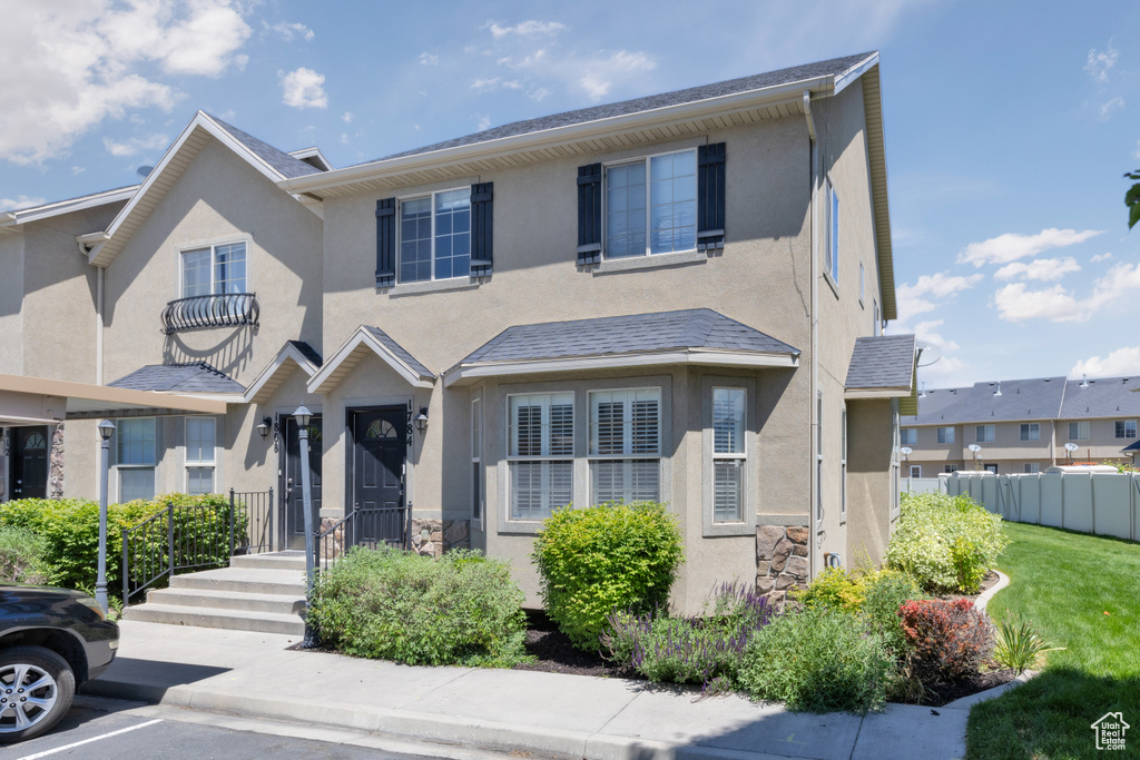 View of property featuring stucco siding and uncovered parking