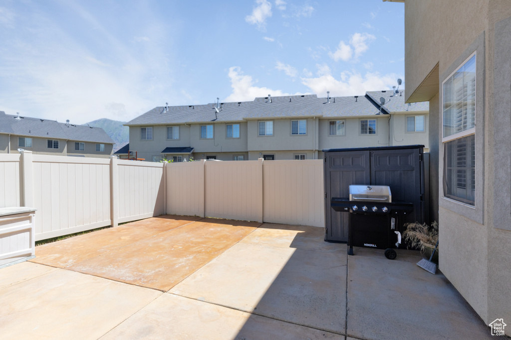 Fenced backyard with a patio area, a grill, and a residential view