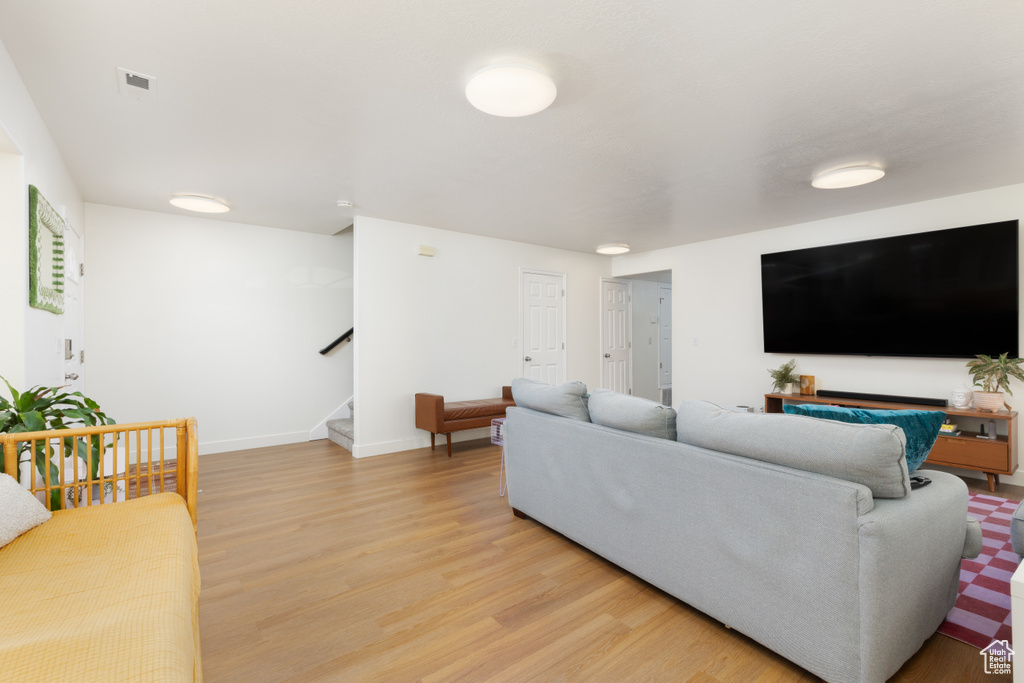 Living room with stairs and light wood-type flooring