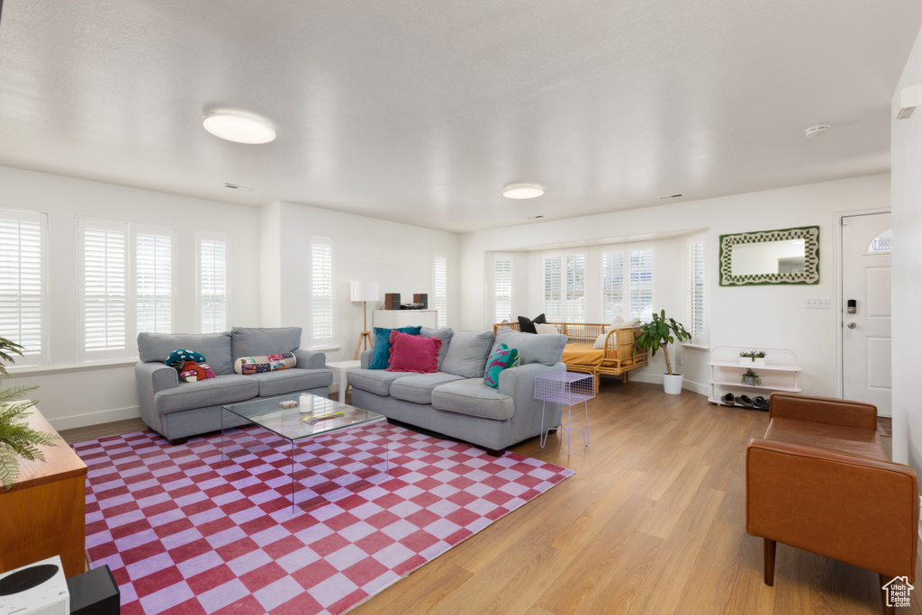 Living room with baseboards and light wood-style flooring