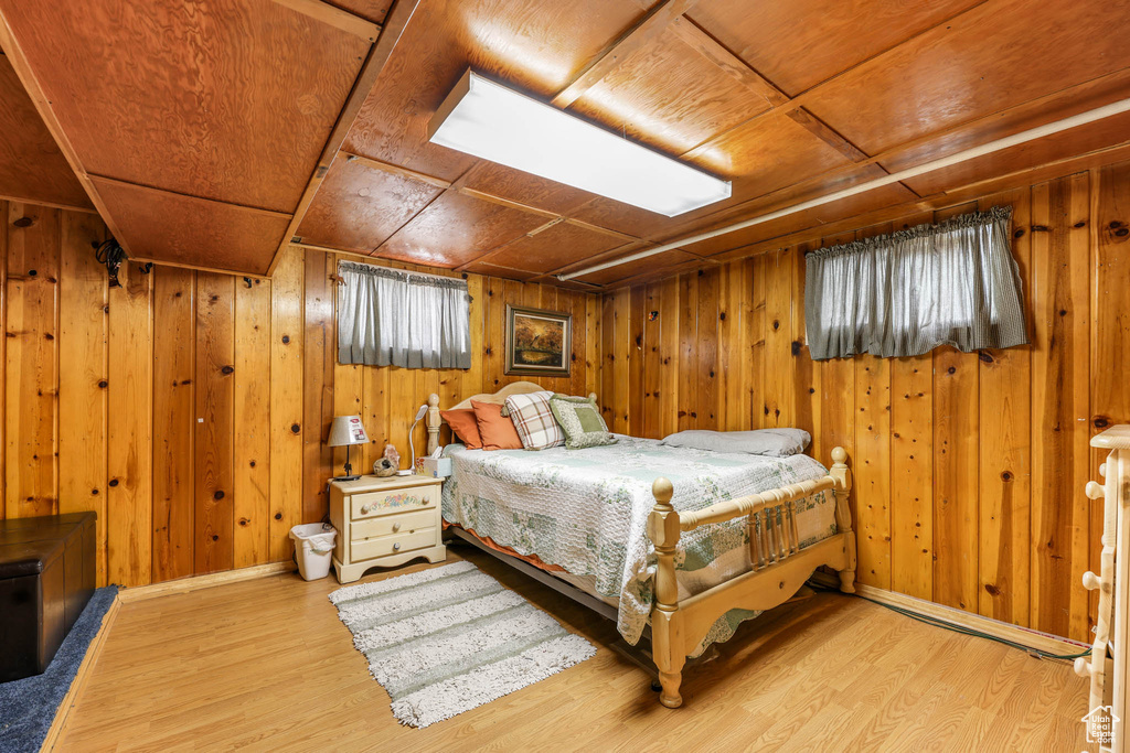Bedroom featuring wood walls and wood finished floors