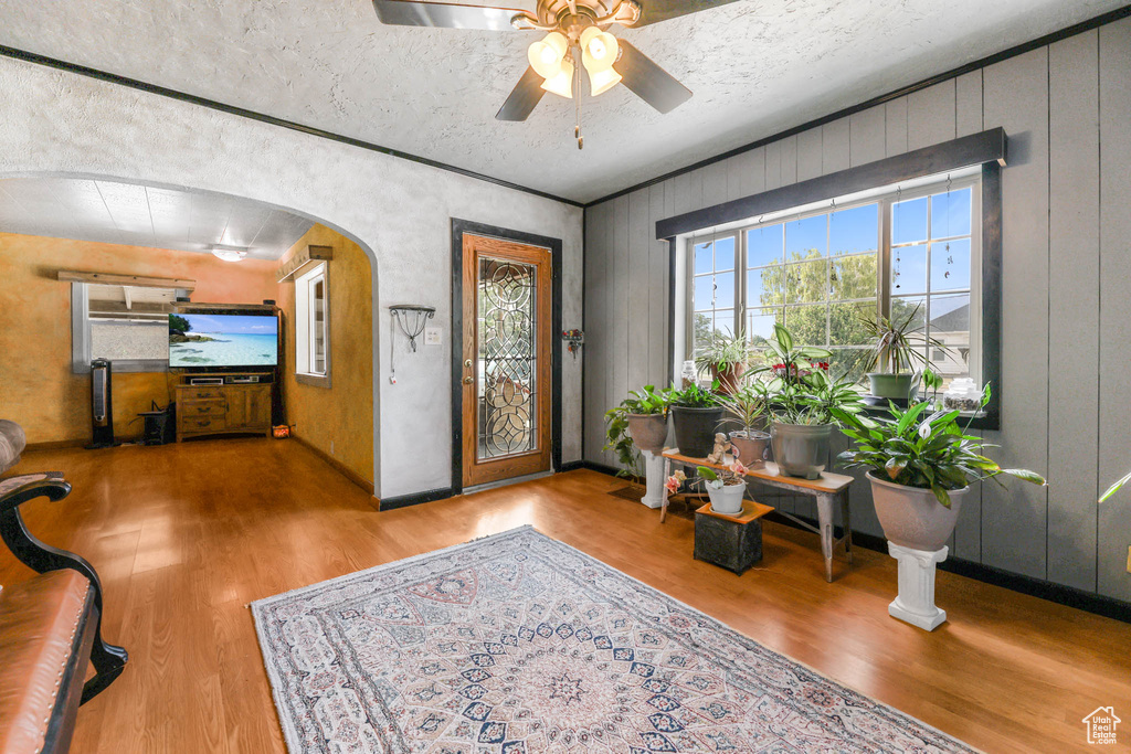Entrance foyer featuring wood finished floors, arched walkways, and ceiling fan