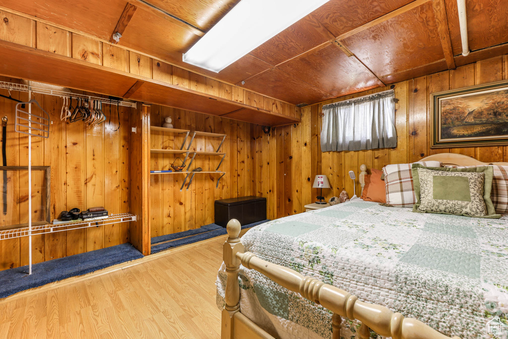 Bedroom featuring wood walls, wood finished floors, and wood ceiling