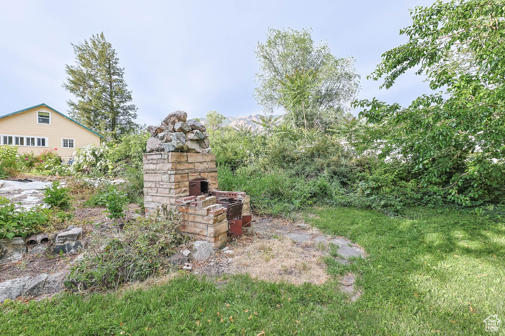 View of yard featuring an outdoor stone fireplace