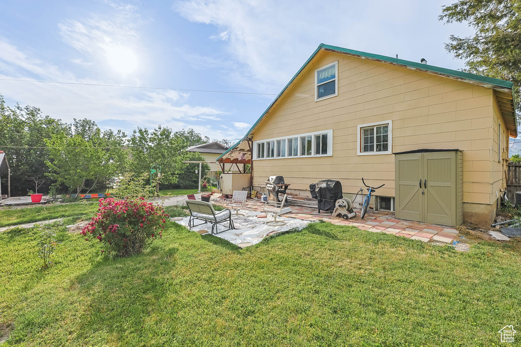 Back of property featuring a yard and a patio area