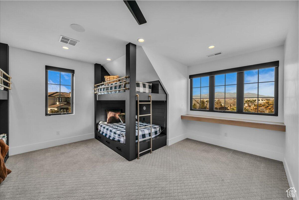 Carpeted bedroom with a ceiling fan and recessed lighting