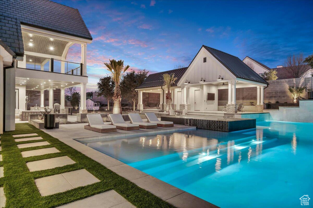 View of swimming pool featuring an outdoor kitchen, an outdoor bar, a patio, and a storage structure