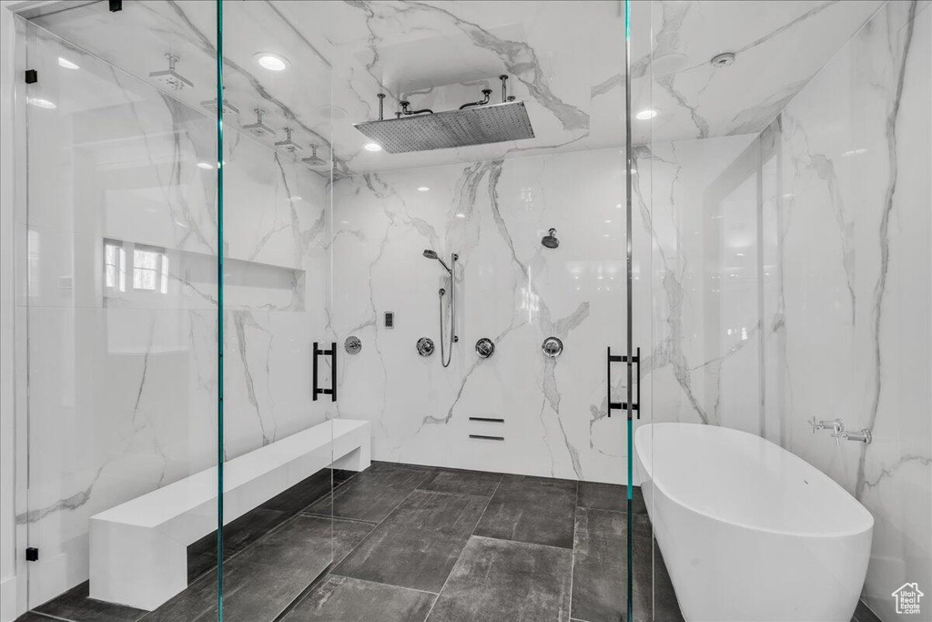 Bathroom with a marble finish shower and a freestanding tub