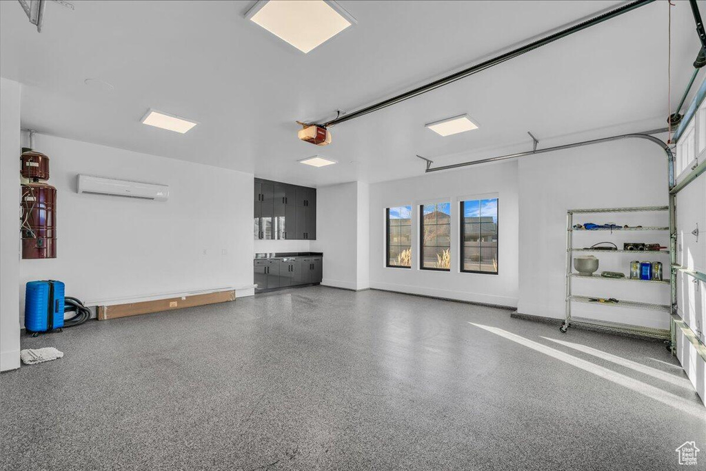 Garage with an AC wall unit and a garage door opener
