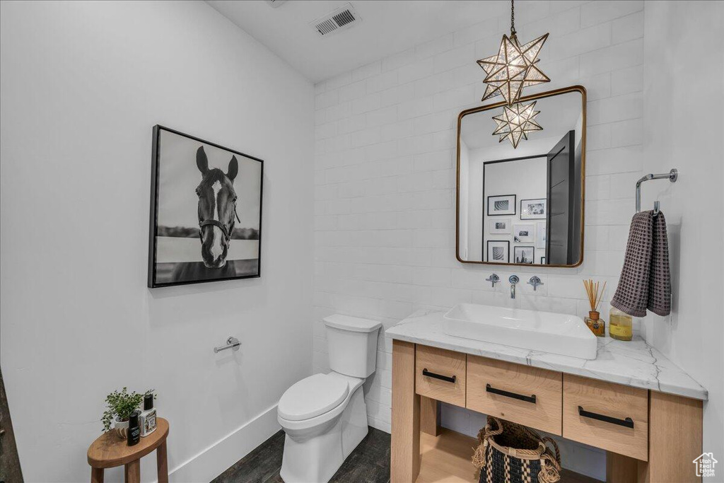 Half bathroom with vanity and wood finished floors