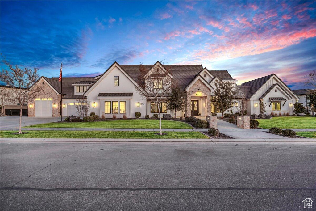 French country inspired facade with stone siding and a front yard