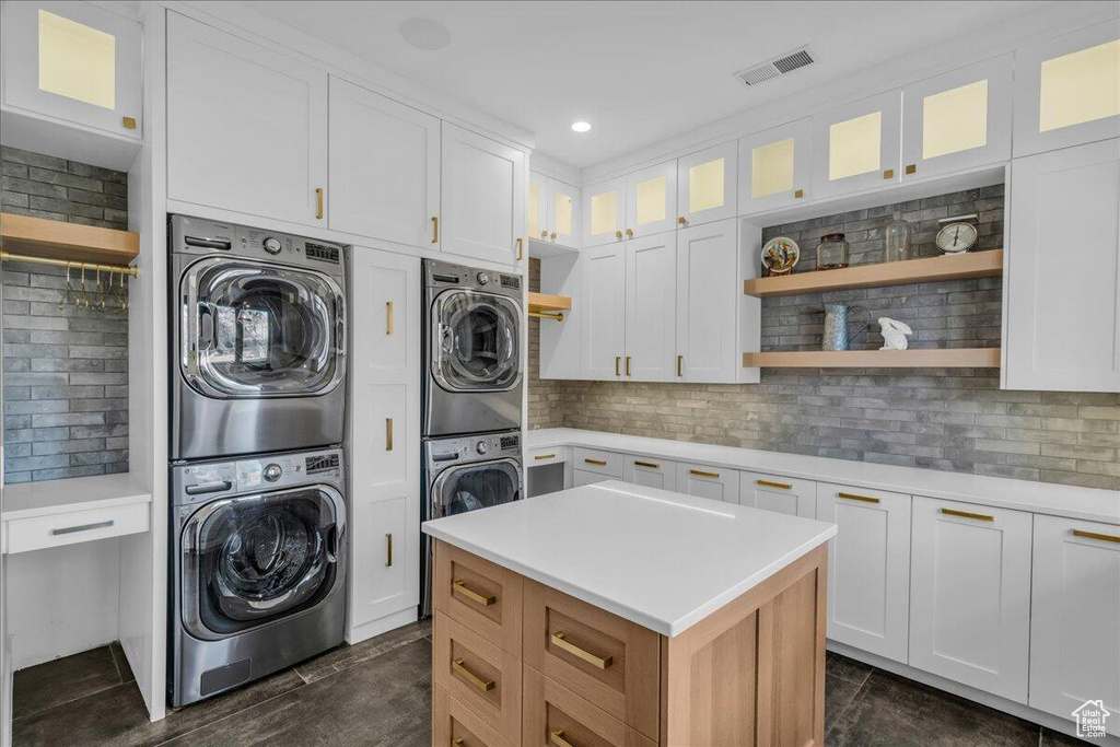 Washroom featuring stacked washer / drying machine and recessed lighting