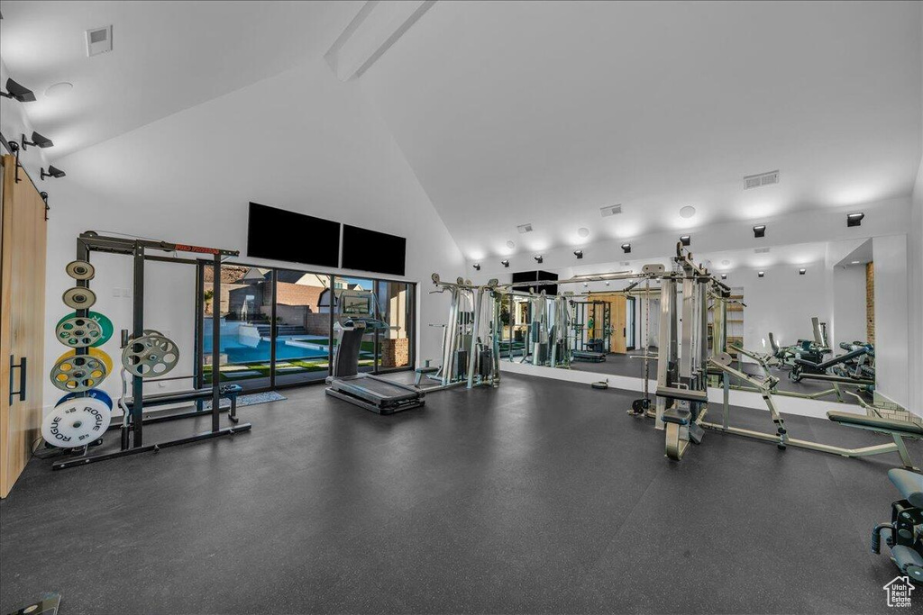 Gym featuring high vaulted ceiling and beam ceiling