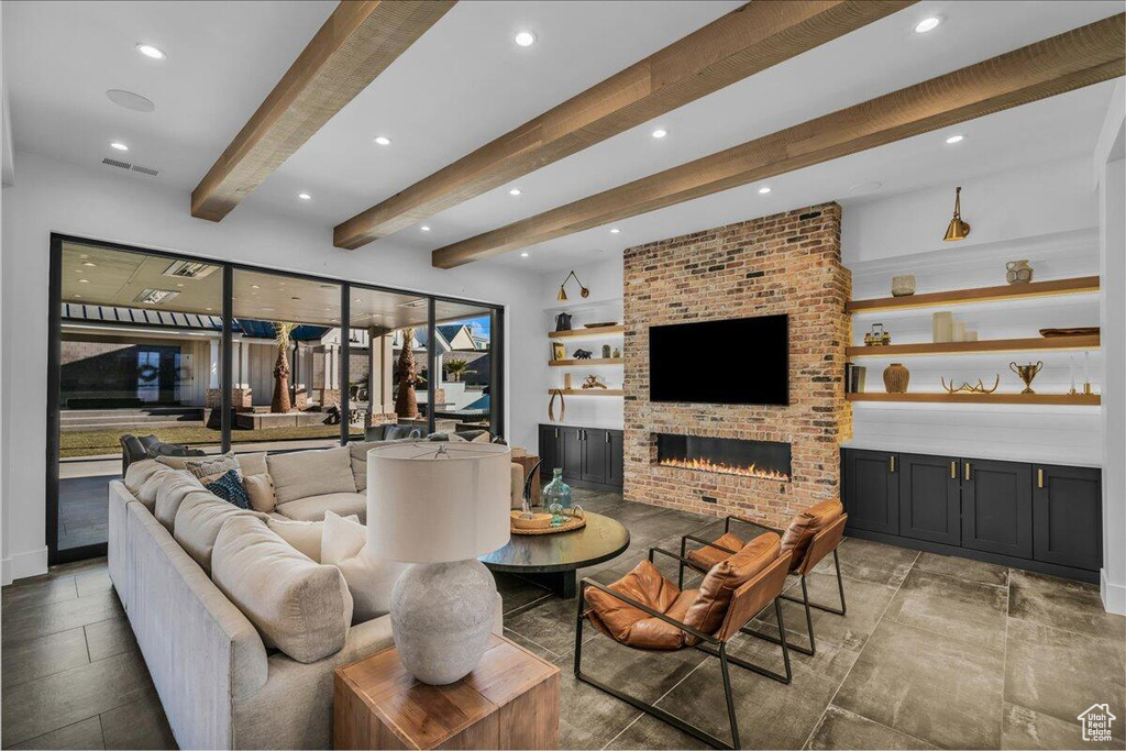 Living room featuring recessed lighting, beamed ceiling, and a brick fireplace