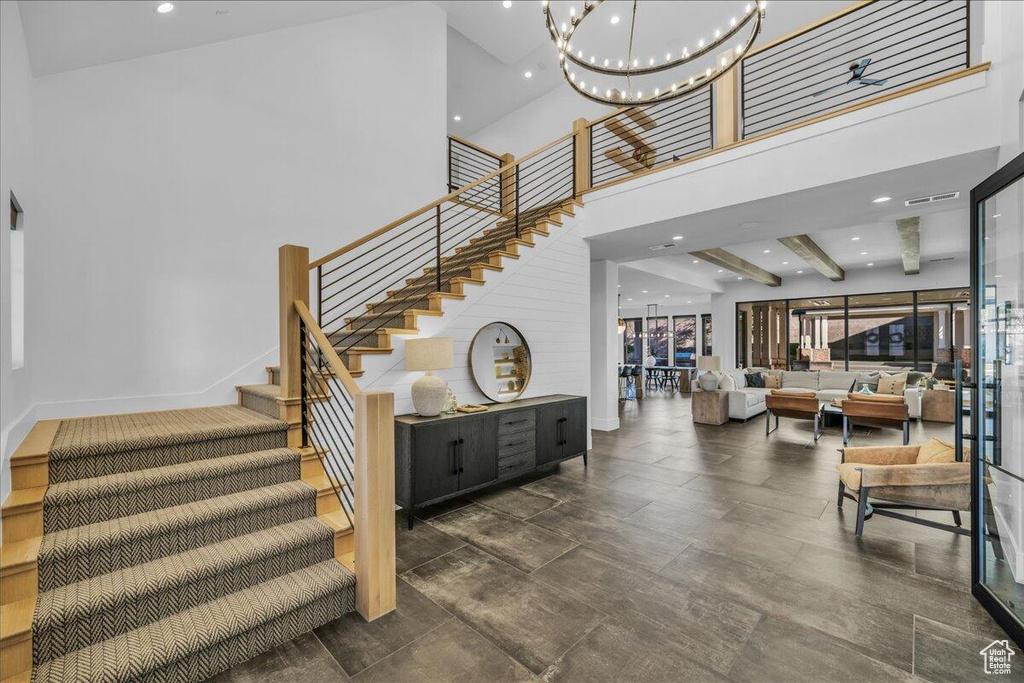 Staircase with a high ceiling, a chandelier, and recessed lighting
