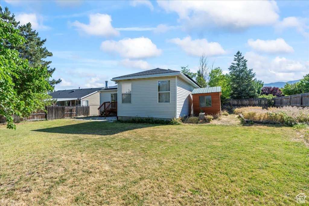 Back of property featuring a fenced backyard and an outbuilding