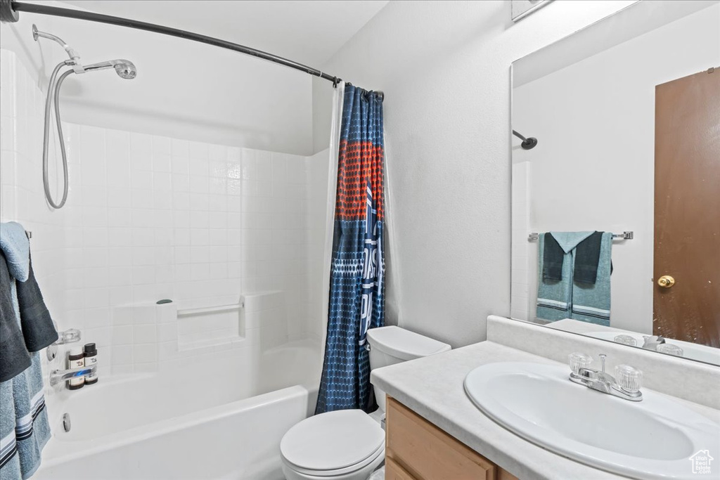 Bathroom with shower / bath combination with curtain and vanity