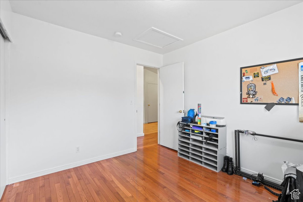 Bedroom with attic access and wood finished floors