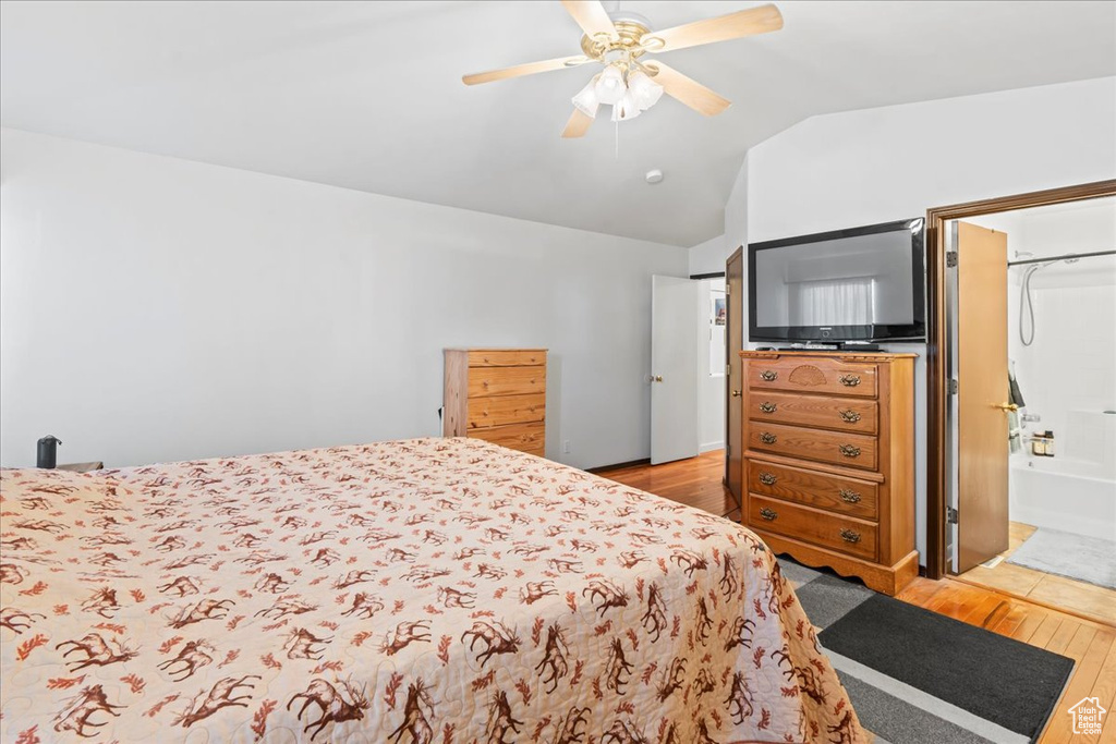Bedroom featuring hardwood / wood-style flooring, vaulted ceiling, and a ceiling fan