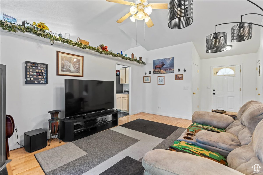Living area with lofted ceiling, light wood-style floors, and a ceiling fan