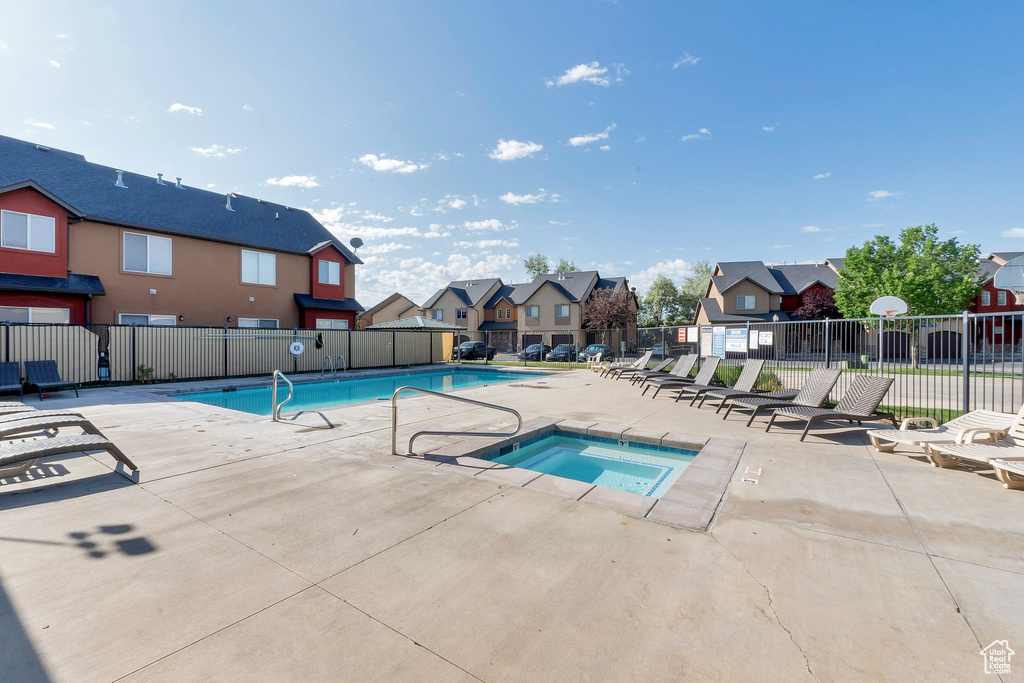Community pool featuring a residential view, a hot tub, and a patio area