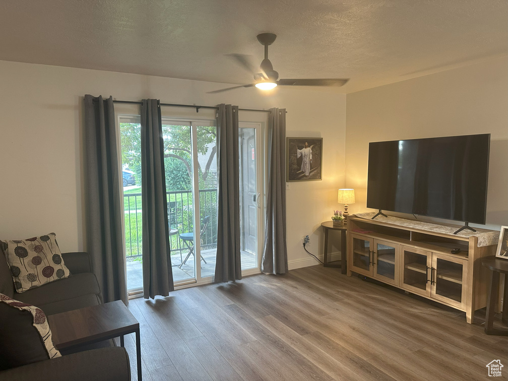 Living area featuring wood finished floors, ceiling fan, and a textured ceiling