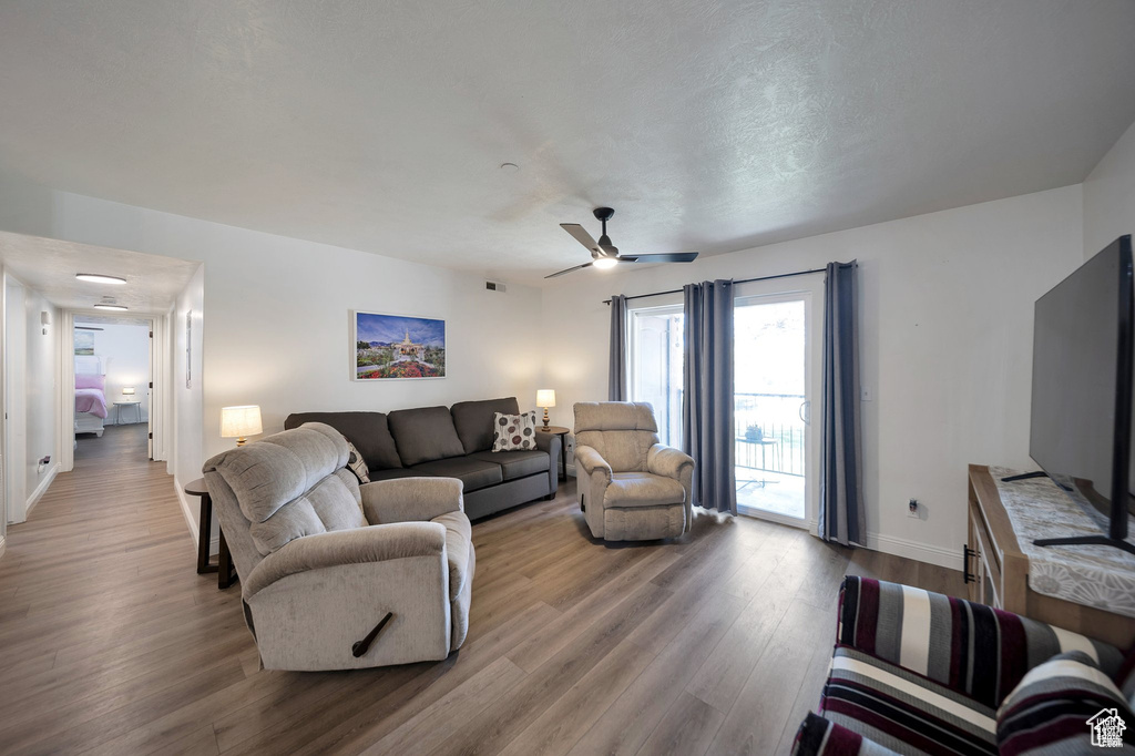 Living room with wood finished floors and ceiling fan