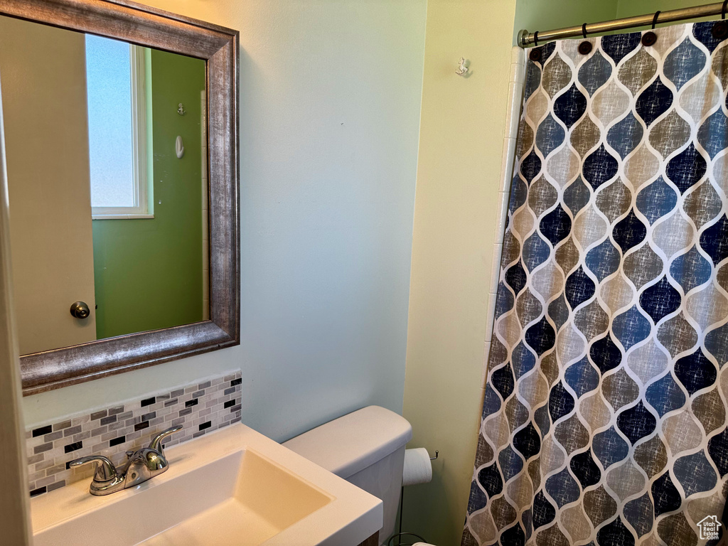 Full bath featuring decorative backsplash, a shower with shower curtain, and vanity