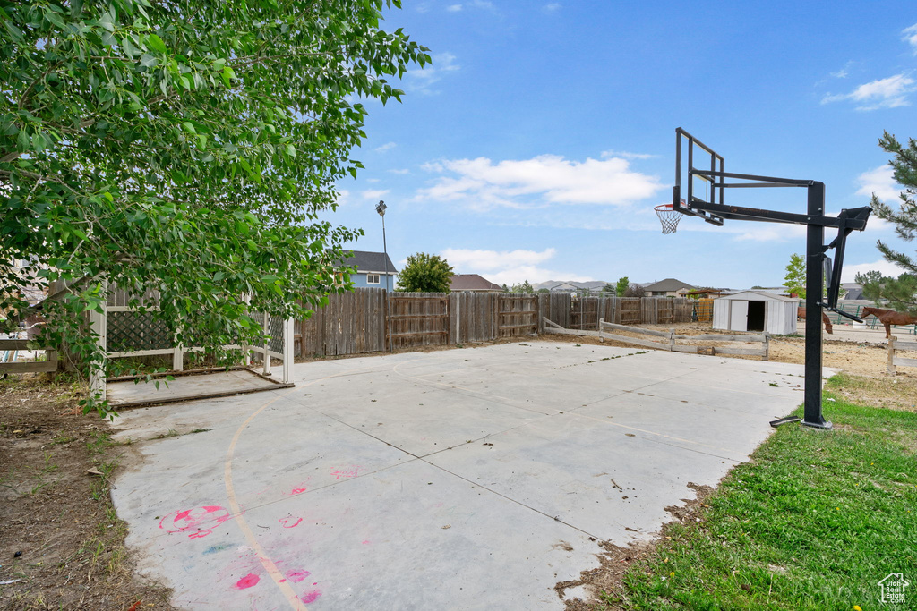 View of patio featuring a storage shed and basketball court