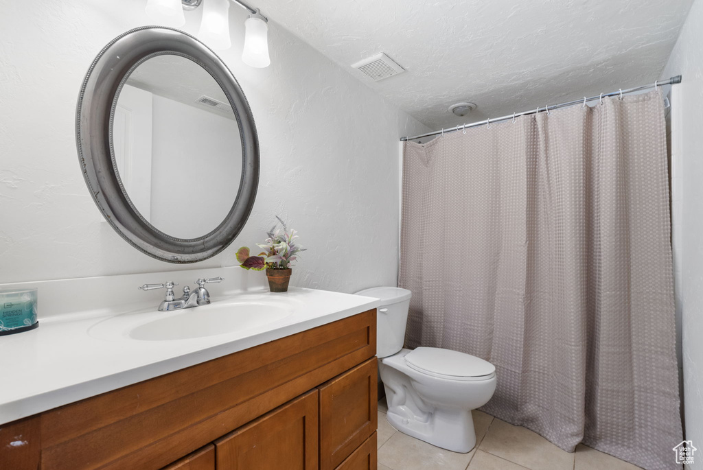 Bathroom with vanity, tile patterned flooring, and a shower with shower curtain