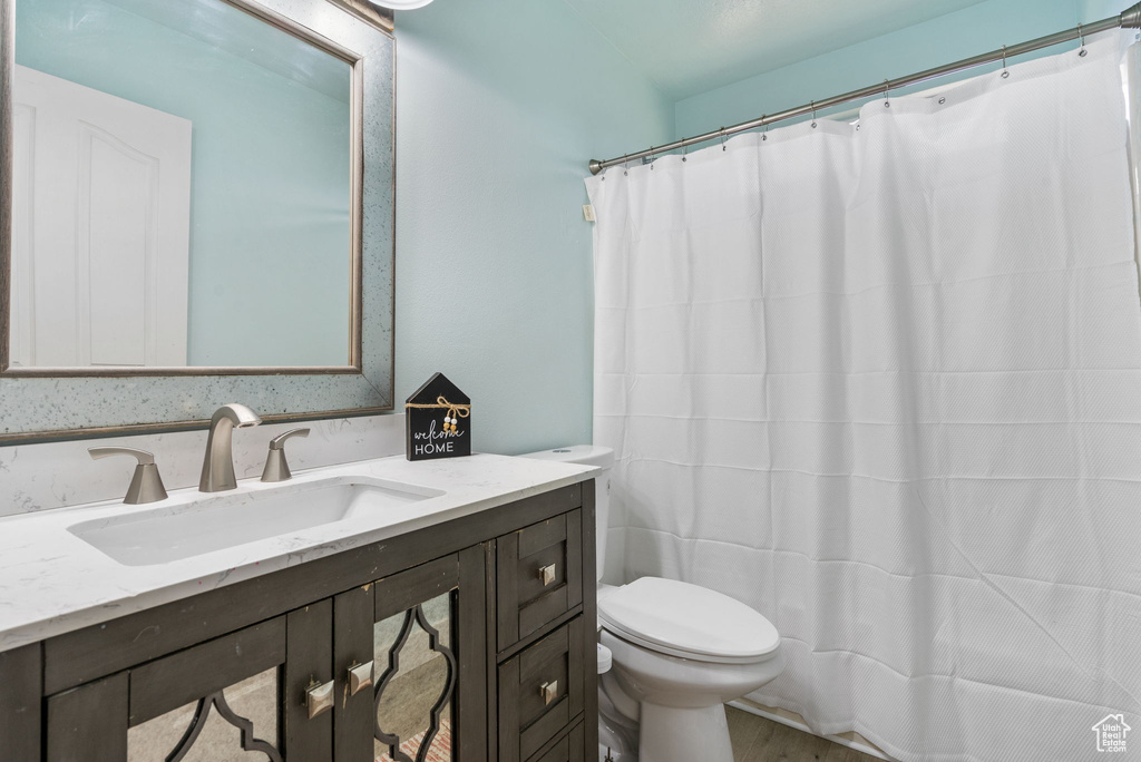 Full bath featuring vanity, wood finished floors, and a shower with curtain