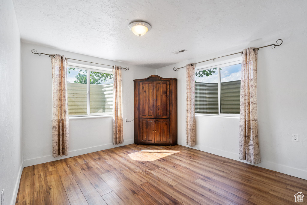 Empty room featuring hardwood / wood-style floors and a textured ceiling