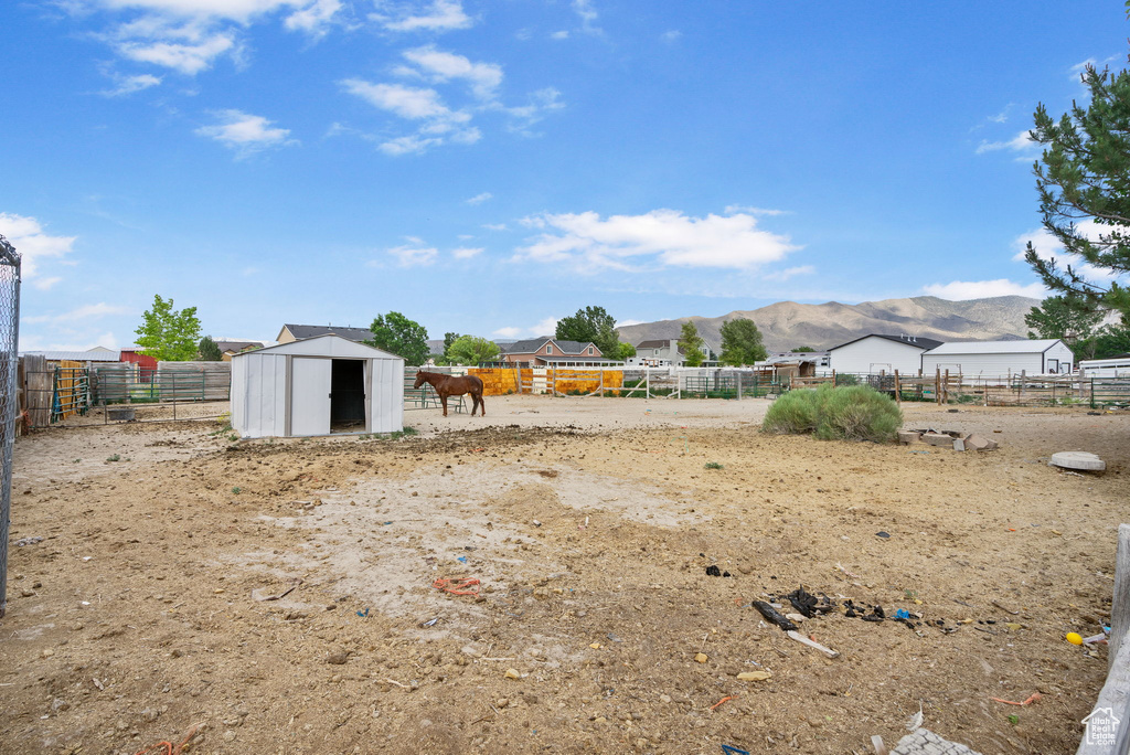 View of yard featuring a mountain view and a storage shed