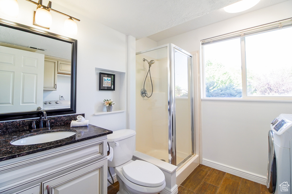 Bathroom featuring a stall shower, vanity, and wood finished floors