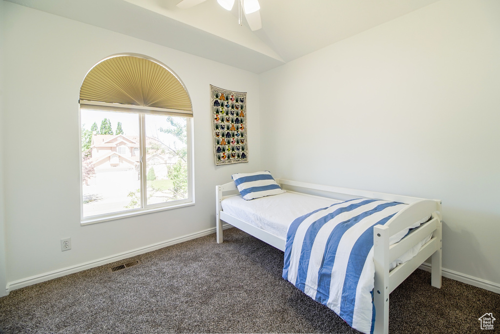 Bedroom featuring carpet flooring, vaulted ceiling, and ceiling fan