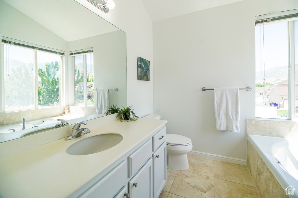 Full bathroom with vanity, a garden tub, and lofted ceiling